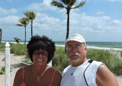 Couple posing in front of the beach.
